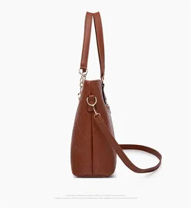 Détail d'un sac à main marron en similicuir matelassé montrant le profil et la chaîne dorée
