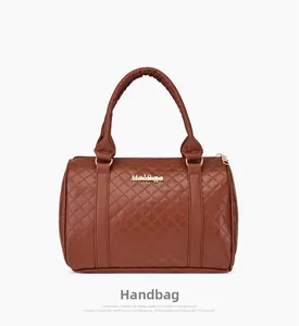 Détail de la texture matelassée en similicuir marron et logo doré sur le sac Boston