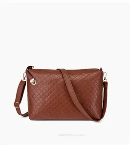 Détail d'un sac à bandoulière matelassé marron foncé avec finitions dorées