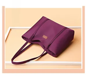 Close-up of deep purple waterproof nylon tote bag with durable fabric handles and leather logo