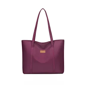 Detailed view of purple nylon tote bag featuring durable fabric and leather logo tag