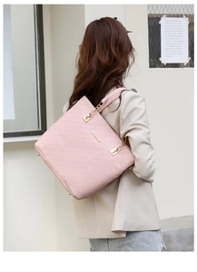 Close-up of pink woven tote bag showing detailed texture and gold metal logo
