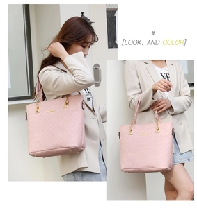 Detail view of light pink woven tote bag with gold chain handles on female model