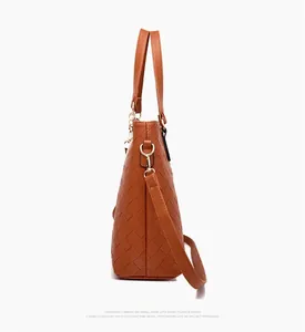 Detailed side view of brown woven leather handbag with adjustable strap and metal buckle
