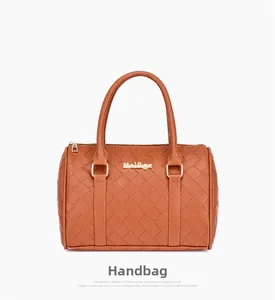 Detail of woven texture and gold hardware on brown Boston style handheld bag