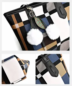 Detail of plaid tote bag featuring checkered pattern, fur ball charm and reinforced stitching