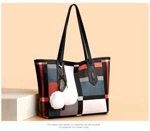 Detailed view of large tote bag featuring geometric color blocking and fur pompom charm
