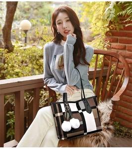Close-up of geometric patterned tote bag with fuzzy ball charms and green leaf detail