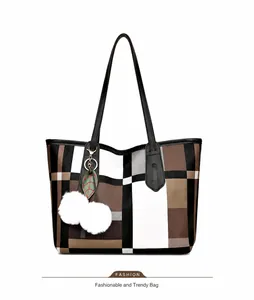 Detail view of large tote bag featuring brown geometric pattern and decorative charms