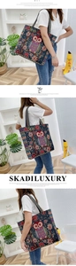 Close-up of vibrant ethnic owl embroidery and striped woven strap on navy canvas tote bag