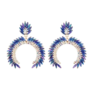 Macro detail of geometric C-shaped earrings with colorful crystals and rhinestones