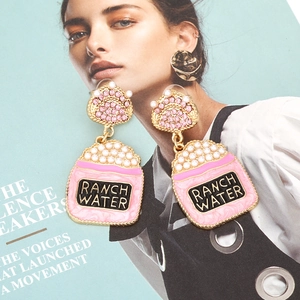 Boucles d'oreilles tasse de thé rose avec logo Ranch Water, perles et strass roses sur magazine