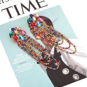 Detail of elegant gold-tone chandelier earrings with colorful rhinestones and tassels