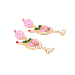Détail macro de boucles d'oreilles verre à cocktail émaillé avec strass et perles