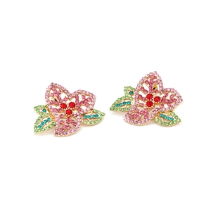 Boucles d'oreilles fleurs colorées avec strass roses et base en alliage doré sur fond blanc
