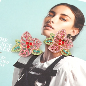 Boucles d'oreilles fleurs avec cristaux colorés sur un fond de magazine de mode chic