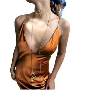 Vintage gold metal flower choker and long pendant necklace set on a female model