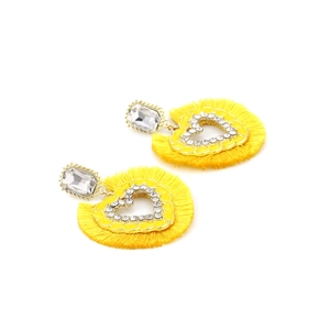 Detail of yellow heart fringe earrings with clear rhinestones and bohemian tassel design