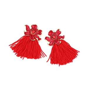 Close-up of red enamel flower earrings with sparkling crystals and long silk tassels