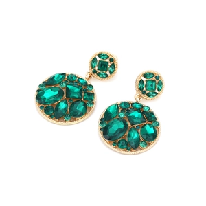 Detailed view of bohemian gold earrings with emerald green gemstones in round hollow design