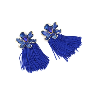 Detail of long blue enamel flower earrings with crystal accents and fringe tassels