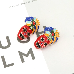 Bunte Totenkopf-Ohrringe mit roter Emaille und floralen Akzenten im Urlaubsstil