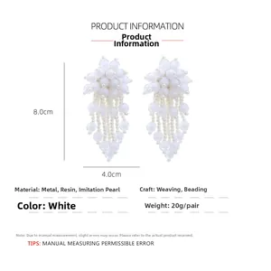 Detail view of white beaded tassel earrings featuring floral motif and 8.0cm length dimensions