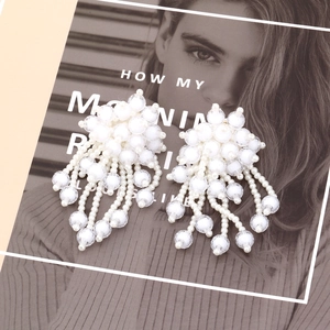 Handmade white beaded floral tassel earrings in a bohemian oversized style for women