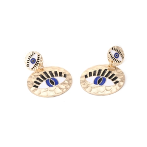 Detailed view of vintage gold hammered evil eye earrings with blue enamel finish
