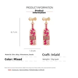 Detail view showing dimensions of pink rhinestone bow champagne bottle earrings for brides