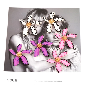 Polka dot flower earrings in white, purple, and pink on a fashion poster background