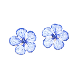 Detail of gradient blue enamel flower earrings with gold metal accents on white background
