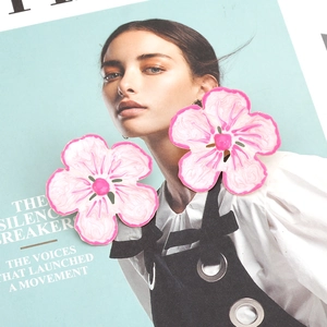 Chic pink gradient flower stud earrings with detailed petal texture on magazine cover