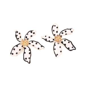Detail of cream flower earrings with black polka dots and gold center hardware