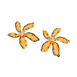 Detailed macro view of orange polka dot flower earrings with black edges and gold centers