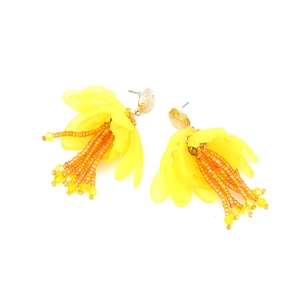 Dettaglio di orecchini a nappa con perline gialle e petali in resina smerigliata