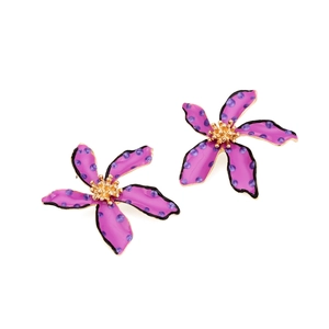 Close-up of purple floral earrings with black polka dots and gold textured core