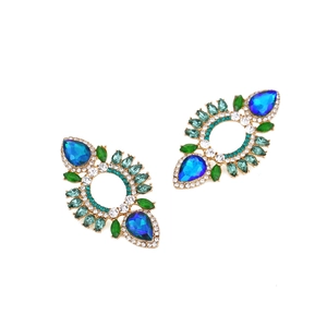 Detailed macro of vintage alloy earrings with colorful rhinestones and pear-cut blue gems
