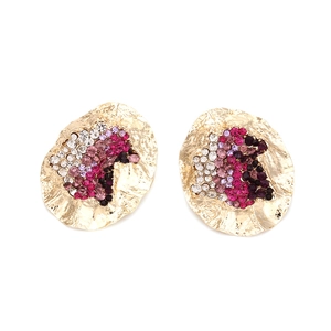 Detailed view of irregular gold earrings with pink and purple gradient crystals
