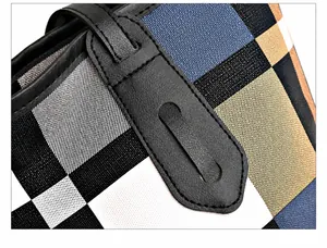 Close-up of durable reinforced stitching on the leather handle of this plaid tote bag