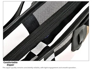 Detail shot of the smooth black zipper and classic plaid fabric texture on a tote bag