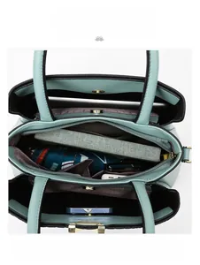 Internal view of mint green handbag showing spacious compartments for iPad and umbrella