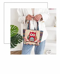 Detalle del bolso boho con bordado de búho rojo y correas tejidas de colores