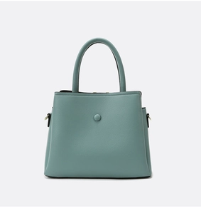 Detailed macro shot of light green lychee texture leather on a stylish handbag