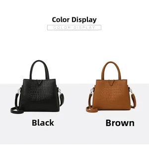 Detail view of crocodile pattern leather handbags in black and brown with metal V-decoration