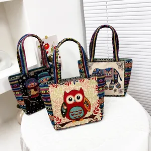 Detailed view of canvas tote bags featuring ethnic owl and elephant embroidery patterns