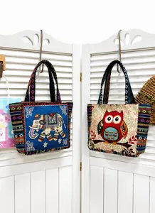 Detail of bohemian tote bags featuring intricate elephant and owl embroidery patterns