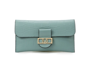 Close-up of crocodile embossed texture on light teal clutch bag with golden V-logo buckle