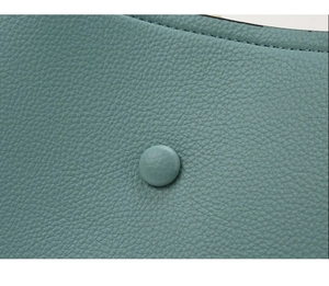 Close-up of cyan lychee texture leather with neat stitching and covered button detail
