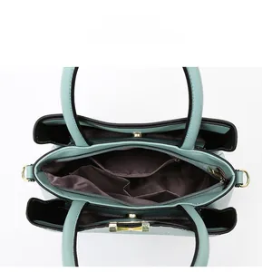 Detail view of the multi-compartment interior and dark fabric lining of the handbag